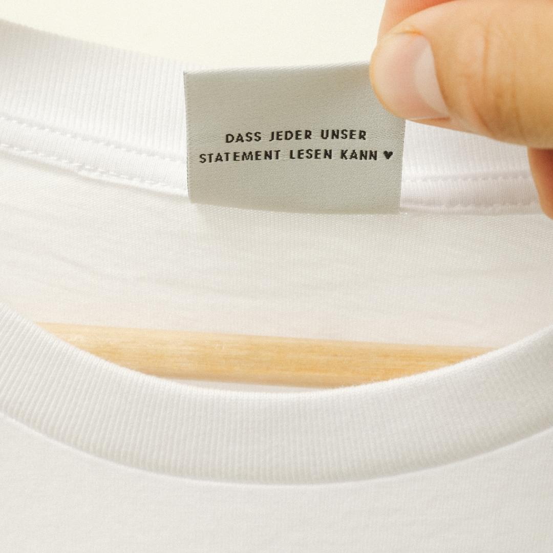 Close-Up: die Rückseite des Etikett des Feel Me T-Shirts, auf dem steht 